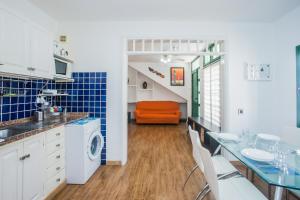 uma cozinha com uma mesa e uma cadeira laranja em Apartamentos Haría en Puerto del Carmen em Tías