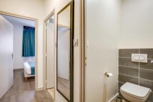 a bathroom with a toilet and a mirror at Jura Hotel Restaurant Le Panoramic in Saint-Claude