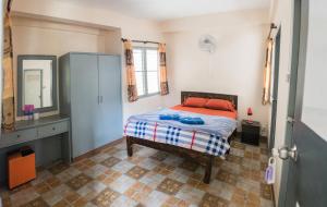 a bedroom with a bed and a dresser and a mirror at Dutch Guest House in Chiang Mai