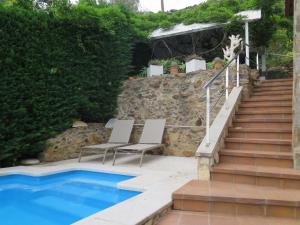 two chairs and stairs next to a swimming pool at Almeria 3 in Roses