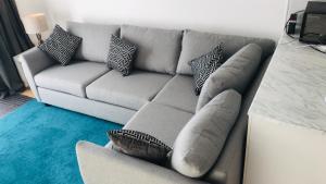 a living room with a gray couch with pillows at Arma Short Stays 46 Bicester - Sleeps 3 - Free Parking & Garden in Bicester