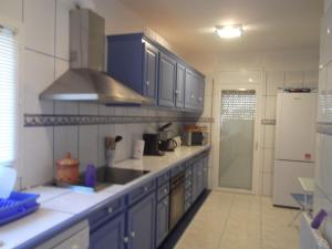 ロザスにあるNavarra 19のキッチン(青いキャビネット、白い冷蔵庫付)