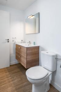 a white bathroom with a toilet and a sink at Flower Beach Suite 16 in Playa Honda