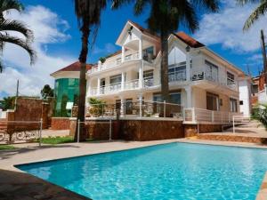 a house with a swimming pool in front of a house at Ivory Castle Limited in Kampala