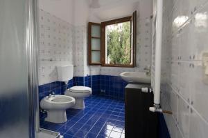 niebiesko-biała łazienka z 2 toaletami i umywalką w obiekcie Villa Moris bed and breakfast w mieście Tavarnelle Val di Pesa +37 zdjęć