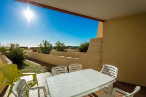 una mesa blanca y sillas en un patio en Résidence de Tourisme l'Albatros, en Palavas-les-Flots