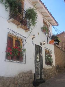 un edificio blanco con macetas y una puerta en Hostal Madre Tierra, en Cusco