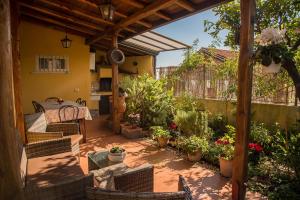 un patio con mesa, sillas y plantas en Holiday Home Luppinedda, en Nunziata