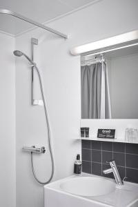 un bagno bianco con lavandino e doccia di Struer Grand Hotel a Struer
