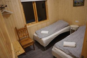 a small room with two beds and a window at Middalskot Cottages in Laugarvatn