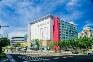 a large building in a city with a parking lot at Kaohsiung Raifong Corner Homestay in Kaohsiung