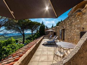 a patio with tables and chairs on a stone building at Garrigae Abbaye de Sainte Croix in Salon-de-Provence