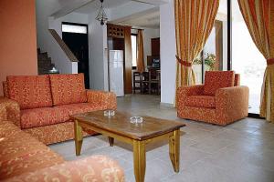 a living room with two couches and a coffee table at VILLA FROSO in Kathikas