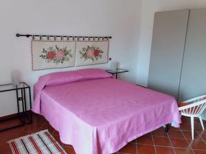 a bedroom with a pink bed and a chair at Miscalè House in Cattolica Eraclea
