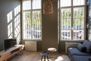 ナンシーにあるLe Petit Carrièreのリビングルーム(窓2つ、青いソファ付)