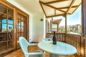 - une table et des chaises sur un balcon avec une bouteille de vin dans l'établissement Spectacular views first line 2 bedrooms apartment, à Santiago del Teide