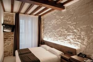 1 dormitorio con 1 cama y una pintura en la pared en Via Aetcal Hotel & Wellness, en Santiago de Compostela