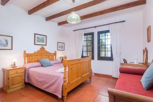 a bedroom with a wooden bed and a couch at Villa Sa Canova by Mauter Villas in Ciutadella +60 photos