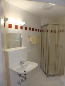 a bathroom with a sink and a shower at Jugendgästehaus St. Gilgen in Sankt Gilgen
