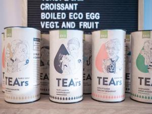 a row of t cans of tea on a table at Linnéplatsens Hotell & Vandrarhem in Gothenburg