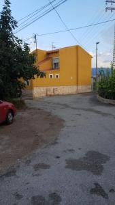 un edificio amarillo con un coche aparcado delante de él en Casa Sofía, en Murcia