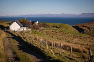 a house on the side of a hill next to the ocean at The Barn Culnacnoc in Culnacnoc