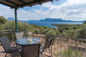 a balcony with a table and chairs and a view of the water at Villa Iliogioma with private pool and sea view in Katomérion