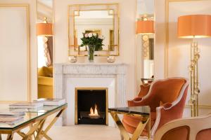 a living room with a fireplace and a mirror at Hotel De Suede Saint Germain in Paris