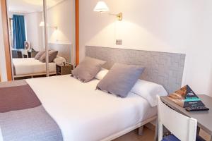 A bed or beds in a room at Hotel Alda Centro Palencia