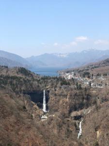 a waterfall in the middle of a mountain with a lake at Shiunso in Nikko