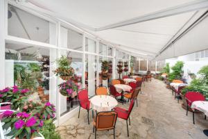 un restaurante con mesas, sillas y flores en Hotel Villa Adriatica - Adults Only, en Supetar