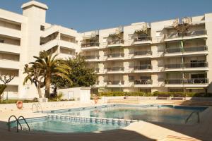 a swimming pool in front of a large building at Somni Cambrils in Cambrils