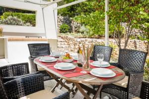 einen Holztisch und Stühle auf einer Terrasse in der Unterkunft Sterna Villa - Contemporary Villa with Private Pool & Sea Views, Fiskardo in Fiskardo
