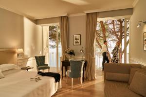 a hotel room with a bed and a table and chairs at Hotel Riviera & Maximilian's in Trieste