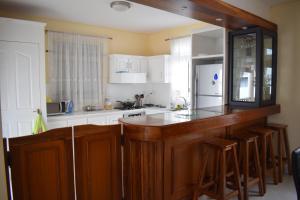 a kitchen with wooden cabinets and a white refrigerator at MAIVA KITE VILLA in La Gaulette