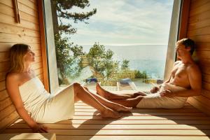 a man and woman sitting on a window sill at Hotel Riviera & Maximilian's in Trieste
