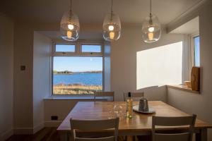 a dining room with a table and a large window at Lochside in Staffin