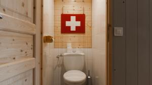ヴァル・トランスにあるLa Roche Blancheのバスルーム(白いトイレ、赤い十字サイン付)