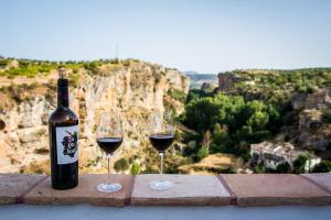 twee glazen rode wijn zittend op een richel bij La Maroma Rooms & Views in Alhama de Granada