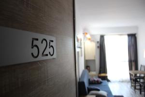 a clock on a wall next to a living room at Studio-Hotel Loft Gudauri in Gudauri +15 photos