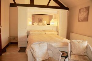 a bedroom with a bed with a mirror and two chairs at Ravencar Farm B&B in Eckington