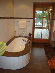 een badkamer met een bad en een veranda bij Haus Andreas in Kitzbühel