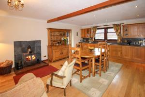 a kitchen and dining room with a table and a fireplace at Dallachulish Lodge in Creagan