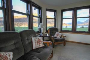 a living room with a couch and chairs and windows at Dallachulish Lodge in Creagan