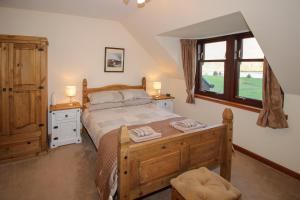 a bedroom with a large bed and a window at Dallachulish Lodge in Creagan