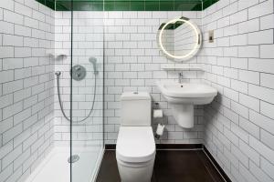 a bathroom with a toilet and a sink and a mirror at ibis Styles London Gloucester Road in London +62 photos