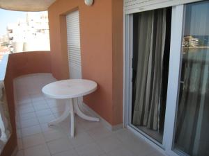mały biały stół w pokoju z balkonem w obiekcie Apartamentos Turísticos Hawaii 4-5 w mieście La Manga del Mar Menor