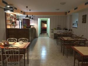 a restaurant with tables and chairs and a kitchen at Penzion Aqua in Martinske Hole