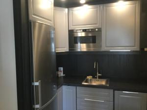 カールスタードにあるSolsidan 1のキッチン(白いキャビネット、ステンレス製の冷蔵庫付)