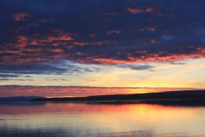 una puesta de sol sobre un gran cuerpo de agua en Kriukot, en Hólmavík